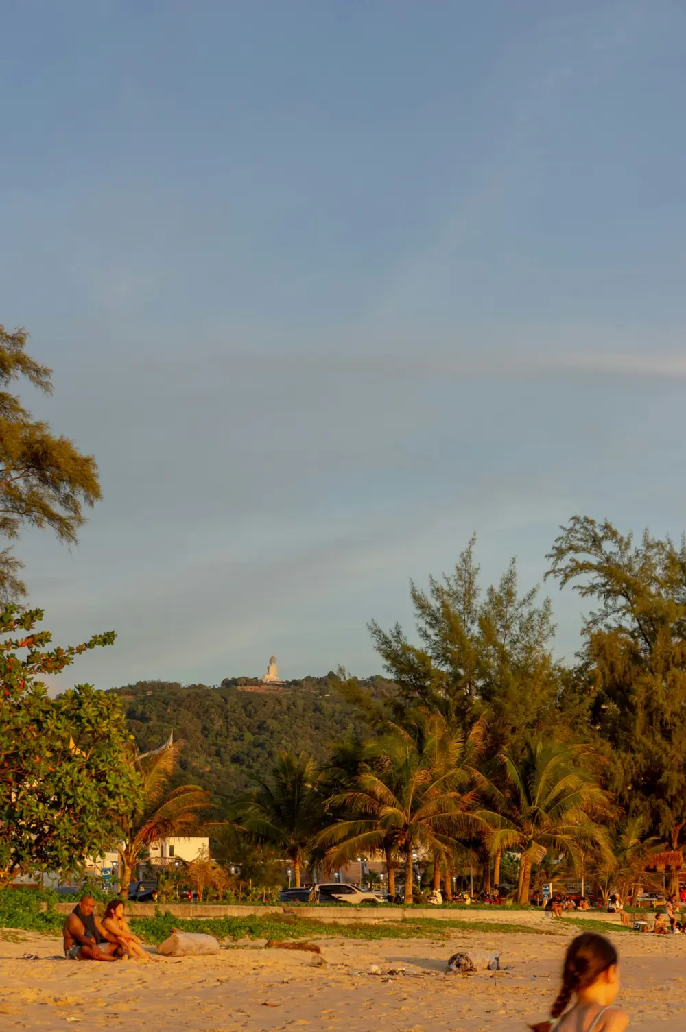 People and trees beside the beach at Karon