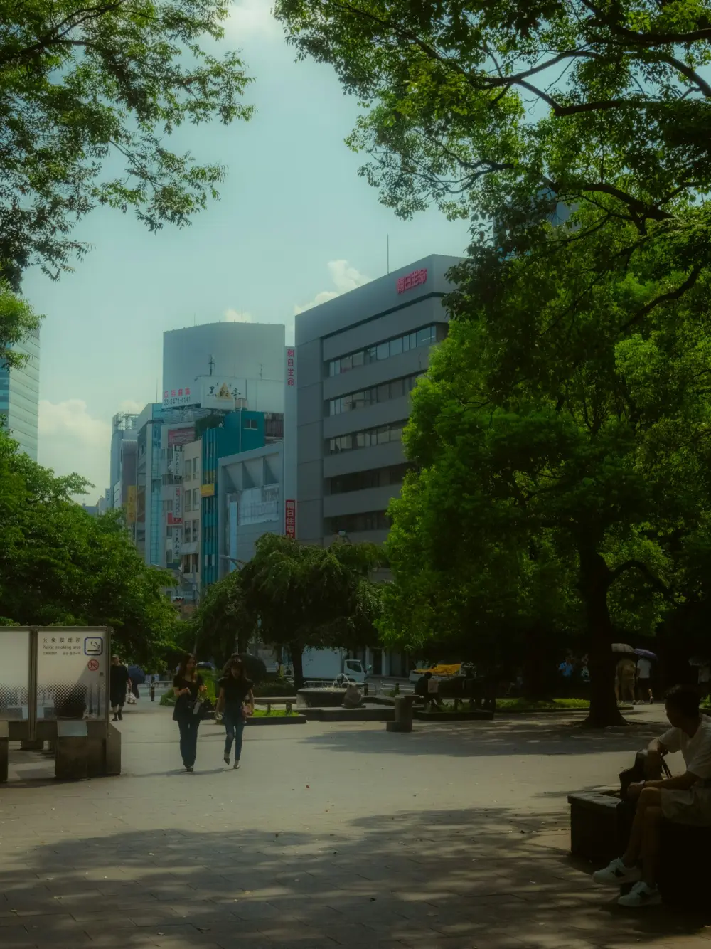 People walking beneath trees in Ueno Park, Tokyo
